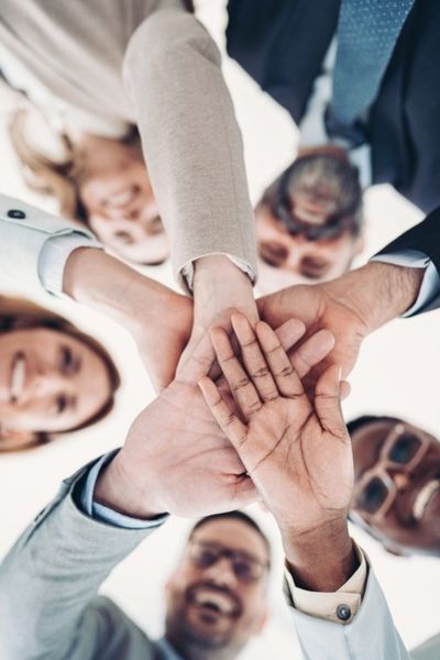 Group of business persons stacking hands in a circle